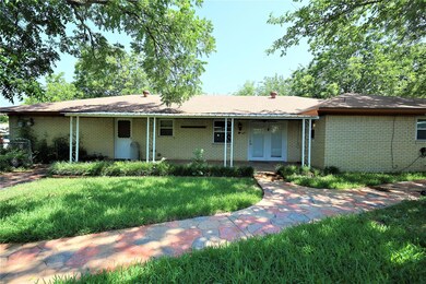 BACK OF HOME WITH STAMPED CONCRETE WALKWAY THROUGH GARDEN