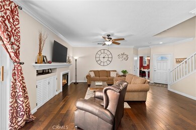 Wood flooring in living room with gas fireplace and custom mantle.