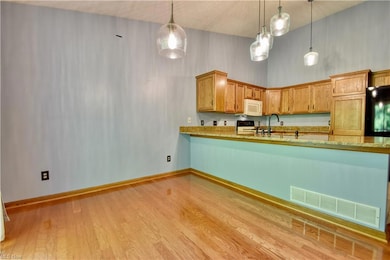 Kitchen featuring decorative light fixtures, range