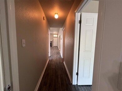 Hallway with baseboards, a textured wall, a textu