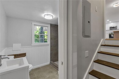 Full bath featuring electric panel, tiled shower, 