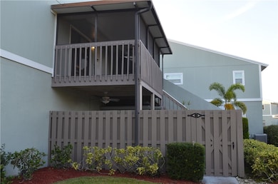 View of side of property featuring a screened balcony, a fenced in patio with entry gate, and ceiling fan