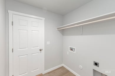 Laundry room featuring light wood finished floors, electric dryer hookup, and washer hookup