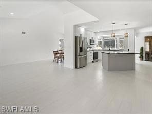 Kitchen with white cabinets, pendant lighting, sin