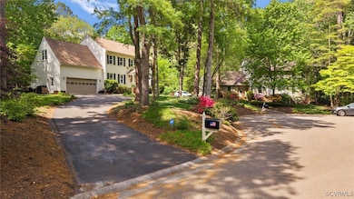 Colonial house featuring a shingled roof and aphal