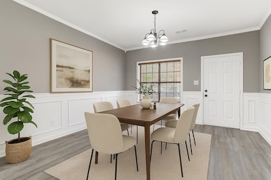 Dining area with wainscoting, a decorative wall, ornamental molding, a chandelier, and light wood-type flooring