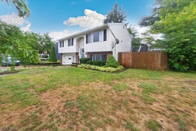 Split foyer home with a garage and a front yard
