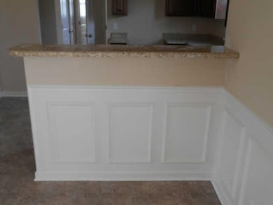 dining room featuring chair rail and wainscoting, breakfast bar between kitchen and dining room