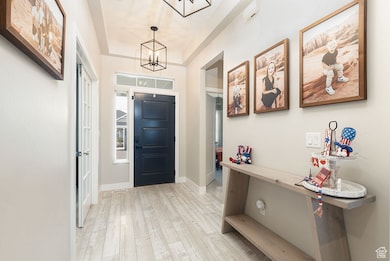 Entryway with a chandelier and light wood finished floors