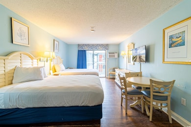 Bedroom featuring a wall mounted AC, a textured ce