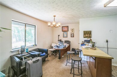 Carpeted office featuring a chandelier and a textured ceiling