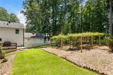 View of green lawn featuring a wooden deck