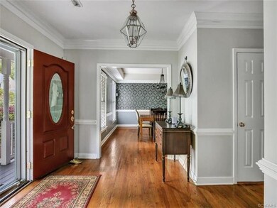 Large foyer with wood floors, chair rail and crown