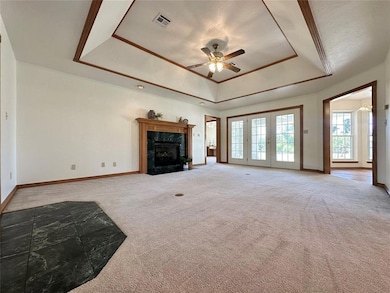 Unfurnished living room with ceiling fan, a tray c