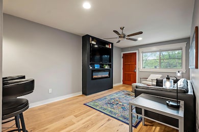 Living room featuring ceiling fan, a fireplace, l