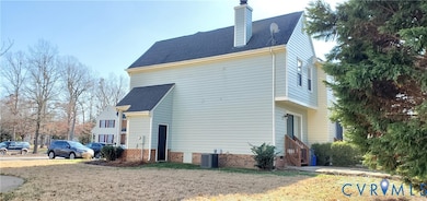 View of side of home with a shingled roof, a chimney, and a yard