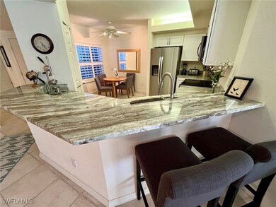 Kitchen with stove, light stone countertops, a pen
