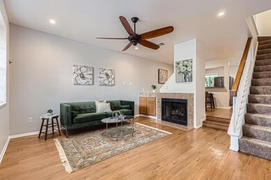 Living room with stairs, ceiling fan, light wood 