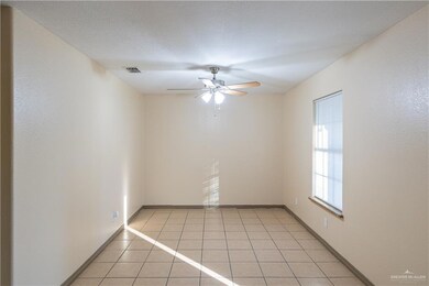 Spare room featuring light tile patterned flooring, a ceiling fan, and a textured ceiling