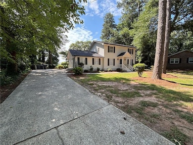 Colonial-style house with asphalt driveway and a front lawn