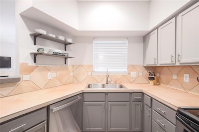 Kitchen featuring gray cabinets, appliances with 