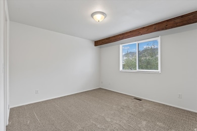 Primary bedroom NEW carpet & pad and beam ceiling