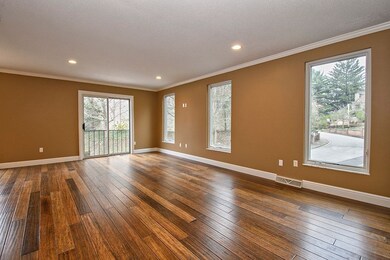 Spacious living room with wood floors and large wi