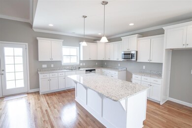 Kitchen features granite countertops with oversized island & soft close birchwood cabinets. All appliances remain excluding fridge. Can upgrade to gas stove easily. Same floor plan in different color palette.