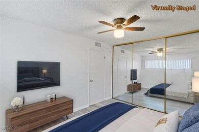 Bedroom with a textured ceiling, wood finished flo