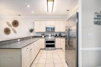 Kitchen featuring stainless steel appliances, light tile patterned flooring, crown molding, recessed lighting, and a peninsula