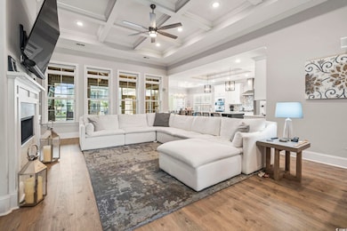 Living area with a chandelier, beam ceiling, recessed lighting, dark wood-type flooring, and coffered ceiling