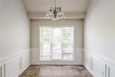 Unfurnished dining area featuring a chandelier
