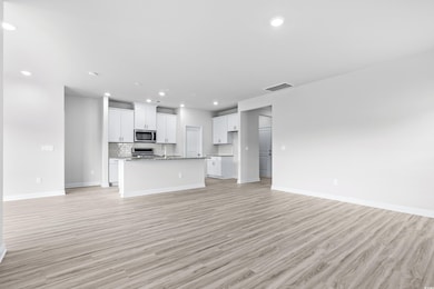 Unfurnished living room with sink and light wood-t