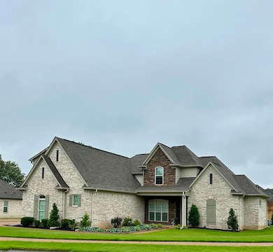 French country home with roof with shingles, a front lawn, and brick siding