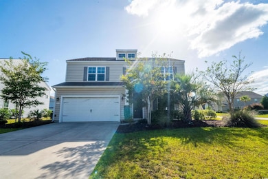 View of front facade featuring a garage, concrete driveway, and a front yard