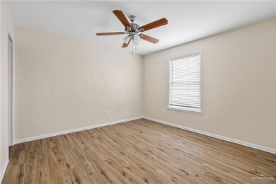 Empty room featuring ceiling fan, baseboards, and wood finished floors