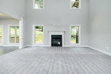 Unfurnished living room with a towering ceiling, c