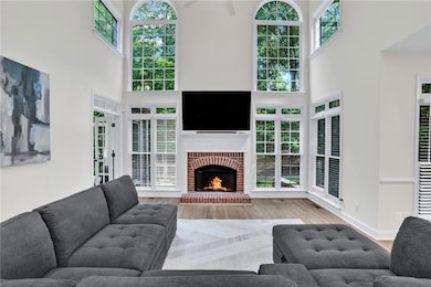 Experience the grandeur of this two-story living room, featuring oversized arched windows, a sleek fireplace, and ample space for both relaxing and entertaining.