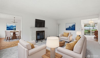 Virtually staged to show off the flexible layout, charming fireplace, and connection to dining spaces.