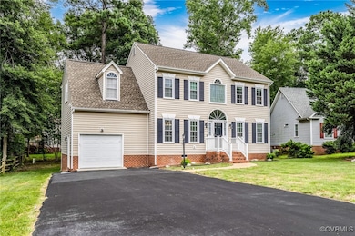Colonial inspired home featuring asphalt driveway,