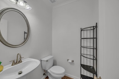 Half bathroom featuring ornamental molding, visib