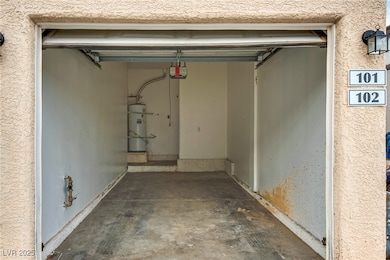 Garage featuring water heater and a garage door opener