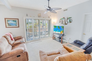 Living area featuring carpet floors, a textured ce