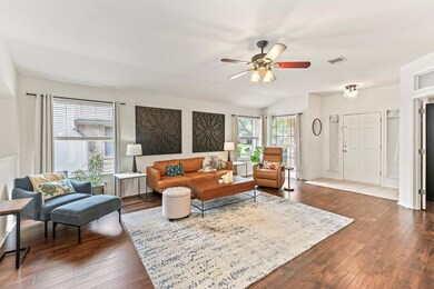 Living room with ceiling fan, dark wood-style flo