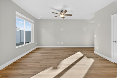 Unfurnished room featuring light wood-type flooring and a ceiling fan