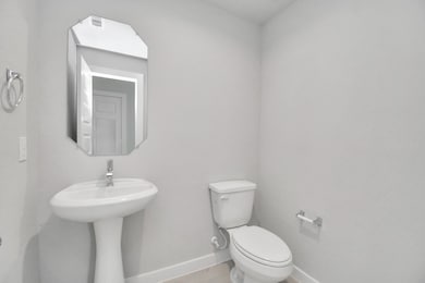 This half bathroom features a stylish pedestal sink, modern hardware, and bright recessed lighting, creating a sleek and inviting space. Sample photo of completed home with similar floor plan. Actual colors and selections may vary.
