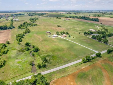 Aerial view of property and surrounding area featuring rural landscape and agricultural land