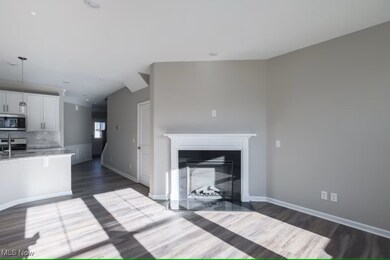 Unfurnished living room featuring a glass covered fireplace and dark wood-style floors