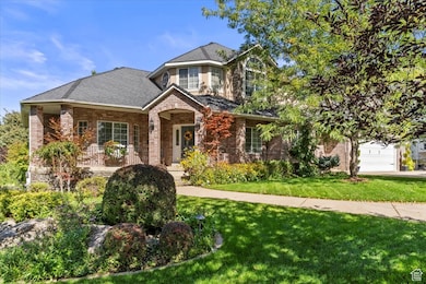 Traditional-style home featuring a porch, brick siding, a front lawn, and a shingled roof