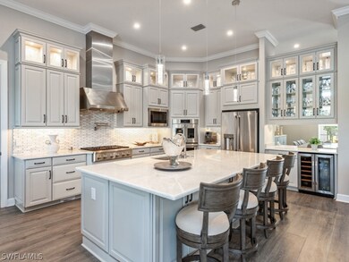 Kitchen with wall chimney range hood, beverage coo